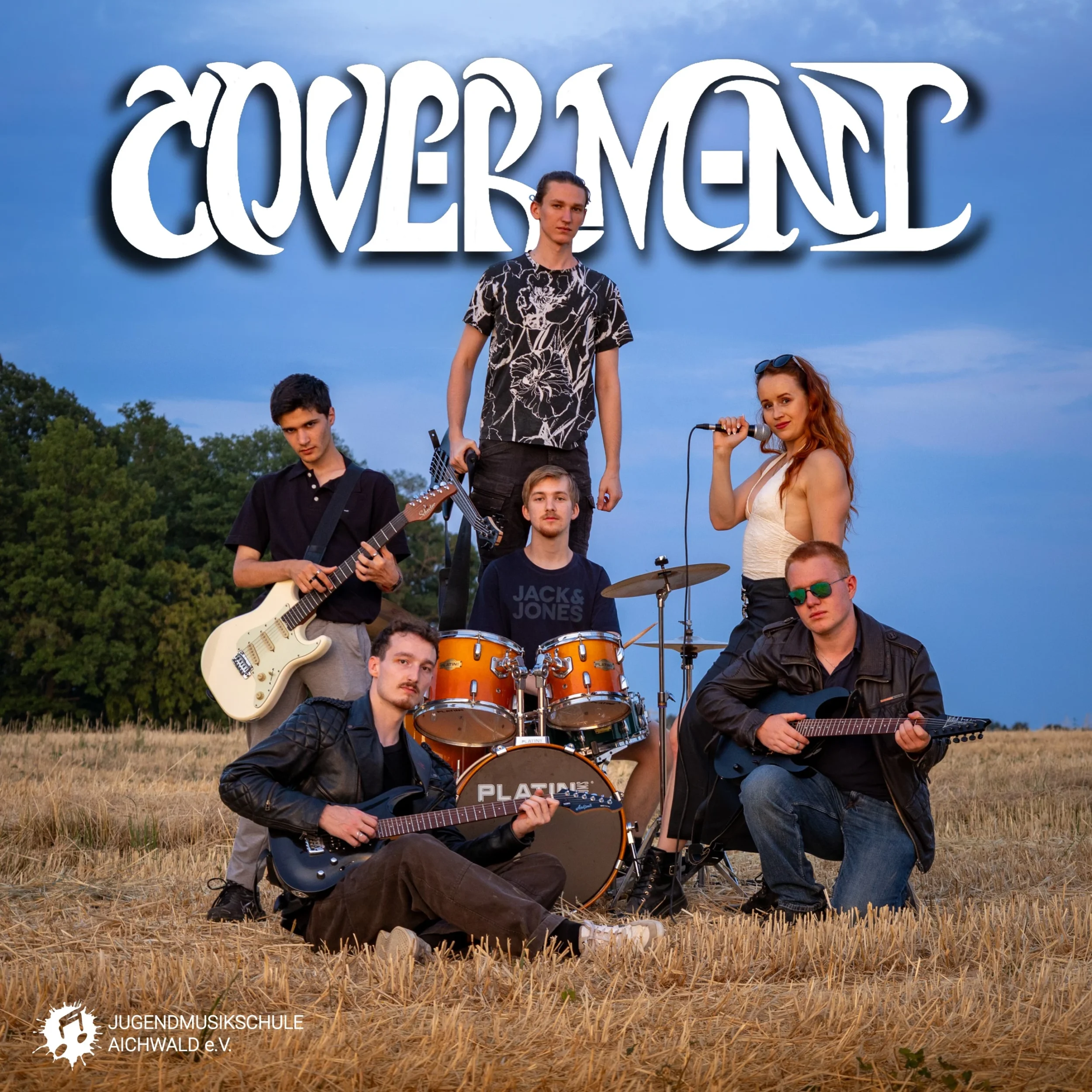 Die Band mit ihren Instrumenten im Kornfeld, oben drüber steht der Schriftzug "Coverment"